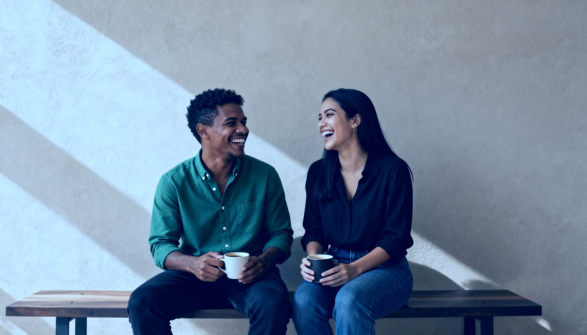 Duas pessoas sorrindo uma para a outra em ambiente de escritório jurídico.